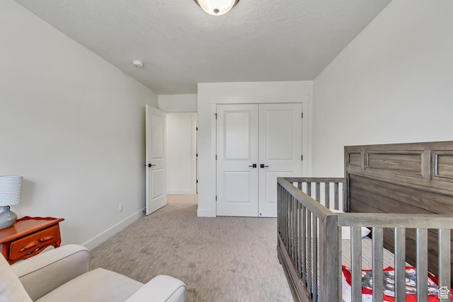 bedroom with baseboards, light carpet, and a closet