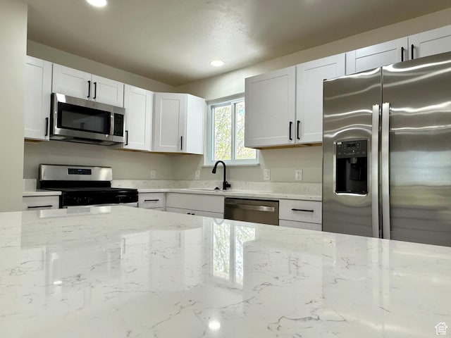 445 Havasu, Tooele, UT 84074 - kitchen featuring appliances with stainless steel finishes, light stone countertops, a sink, recessed lighting, and white cabinets