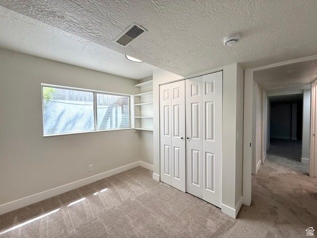 445 Havasu, Tooele, UT 84074 - unfurnished bedroom featuring light carpet, baseboards, a closet, and a textured ceiling