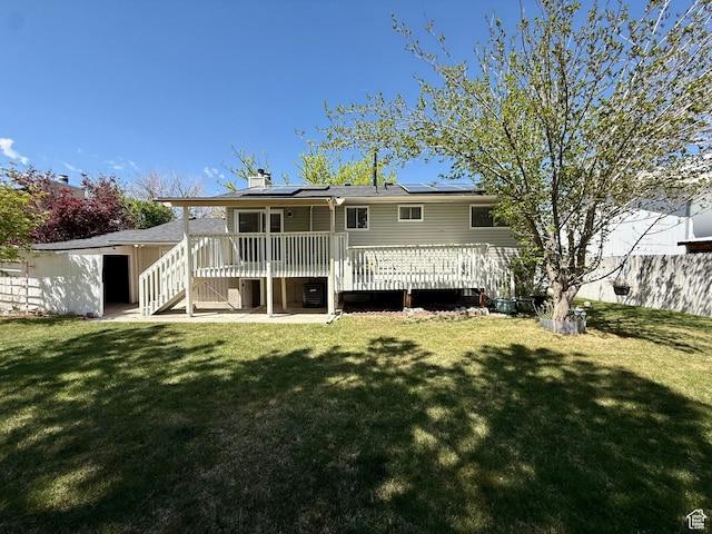 445 Havasu, Tooele, UT 84074 - rear view of property with roof mounted solar panels, a wooden deck, a yard, a chimney, and stairs