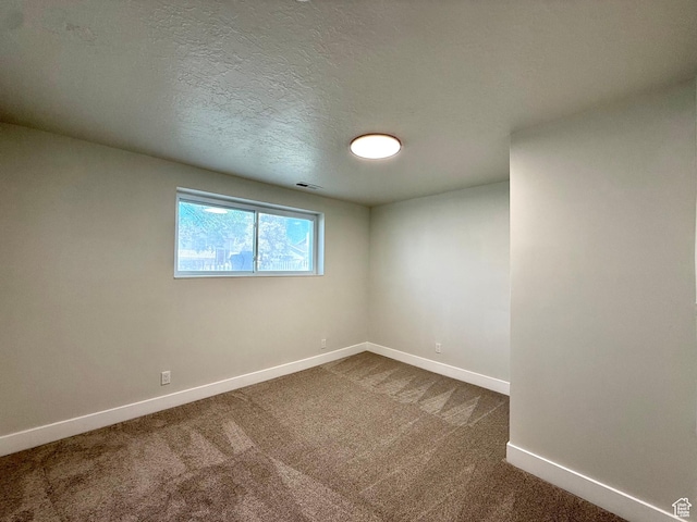 445 Havasu, Tooele, UT 84074 - unfurnished room featuring baseboards, dark carpet, and a textured ceiling