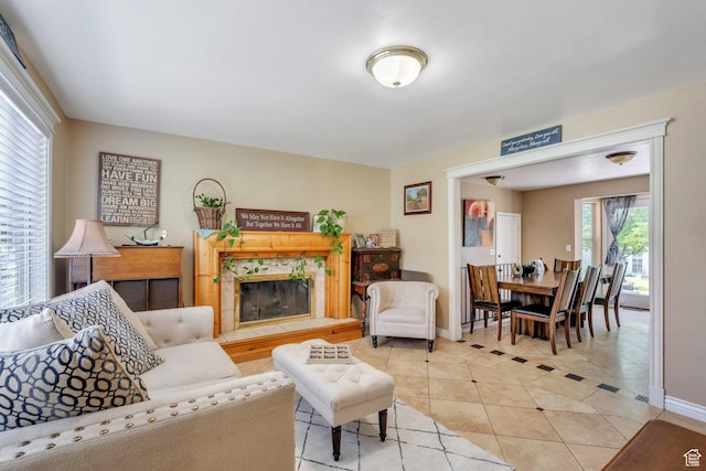 living area with light tile patterned floors, baseboards, and a fireplace