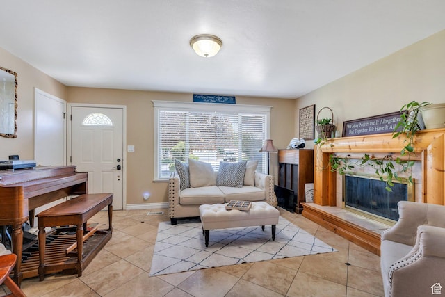 living area with a fireplace, plenty of natural light, light tile patterned flooring, and baseboards