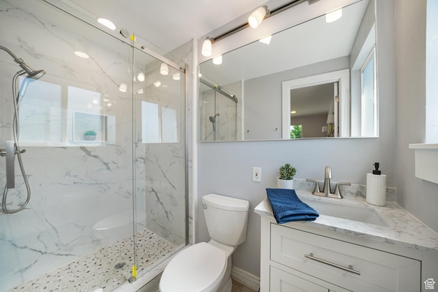 full bathroom with toilet, a marble finish shower, and vanity