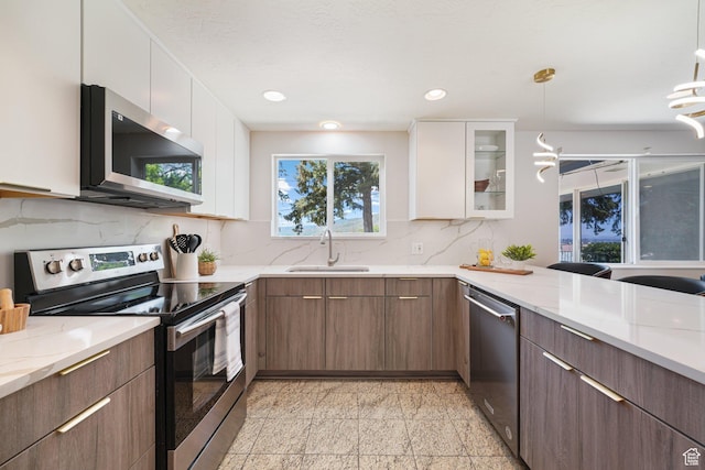 3501 E Loren Von Dr, Millcreek, UT 84124 - kitchen with stainless steel appliances, a sink, granite floors, white cabinetry, and recessed lighting