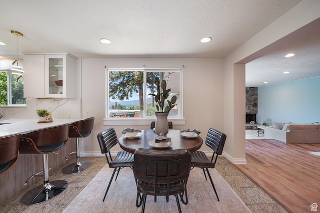 3501 E Loren Von Dr, Millcreek, UT 84124 - dining space with recessed lighting, baseboards, a textured ceiling, and a fireplace