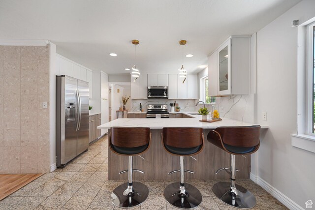 3501 E Loren Von Dr, Millcreek, UT 84124 - kitchen featuring appliances with stainless steel finishes, a peninsula, a sink, glass insert cabinets, and recessed lighting