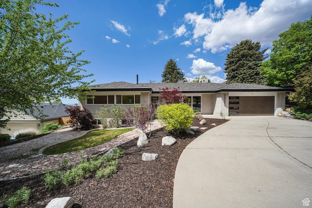 view of front of house featuring an attached garage, concrete driveway, and brick siding