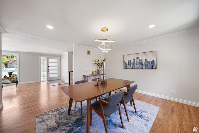 dining room featuring crown molding, baseboards, light wood-style floors, recessed lighting, and a chandelier