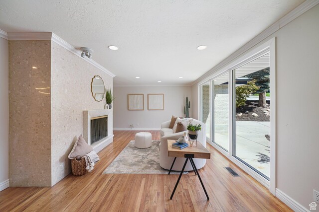 3501 E Loren Von Dr, Millcreek, UT 84124 - living area featuring wood finished floors, a fireplace, ornamental molding, baseboards, and recessed lighting
