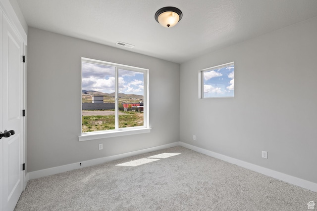 empty room with carpet and baseboards