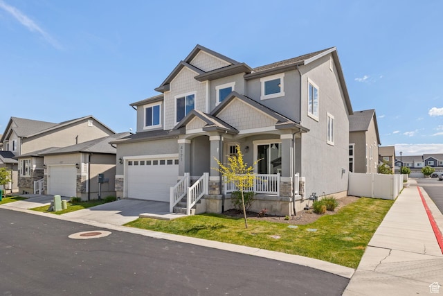 craftsman house featuring concrete driveway, an attached garage, a porch, a residential view, and stucco siding