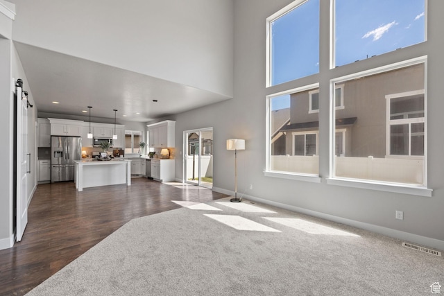 unfurnished living room with baseboards, dark wood-type flooring, and recessed lighting