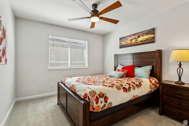 carpeted bedroom featuring baseboards and ceiling fan