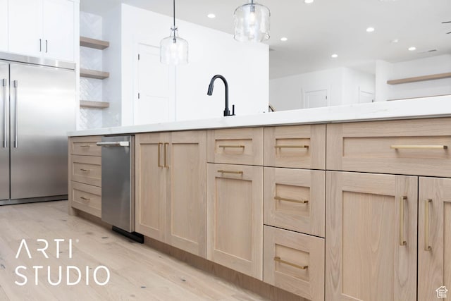 kitchen featuring light brown cabinetry, stainless steel appliances, open shelves, light wood-style flooring, and recessed lighting