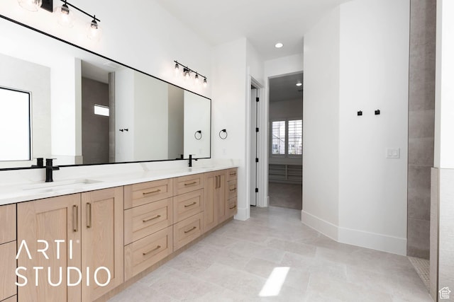 bathroom featuring double vanity and baseboards