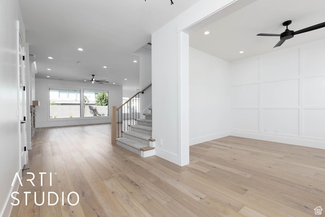 stairs with a ceiling fan, recessed lighting, hardwood / wood-style flooring, a decorative wall, and baseboards