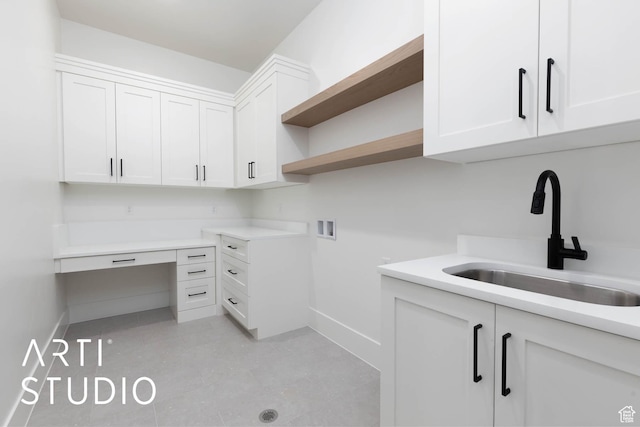 laundry area with hookup for a washing machine, baseboards, and cabinet space