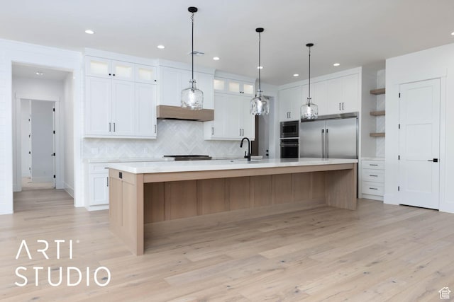 kitchen featuring built in appliances, white cabinetry, light countertops, tasteful backsplash, and recessed lighting