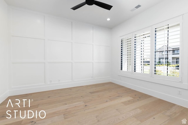 spare room with a decorative wall, ceiling fan, light wood-style flooring, recessed lighting, and baseboards