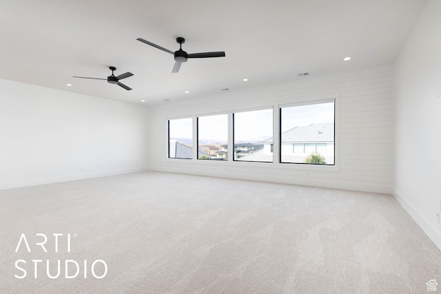 spare room featuring light carpet, recessed lighting, ceiling fan, and baseboards