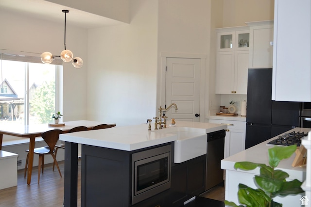 4901 N Eagle Nest Ln, Lehi, UT 84043 - kitchen with black appliances, light countertops, a sink, white cabinets, and decorative light fixtures