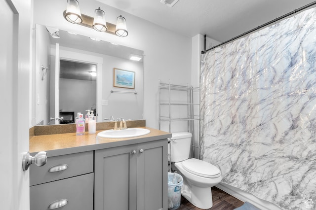 bathroom featuring wood finished floors, vanity, toilet, and a shower with curtain