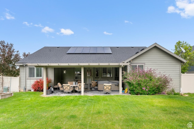 rear view of property featuring a patio area, solar panels, a hot tub, and roof with shingles