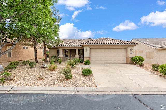 view of front of property featuring a garage, stucco siding, concrete driveway, and a tiled roof