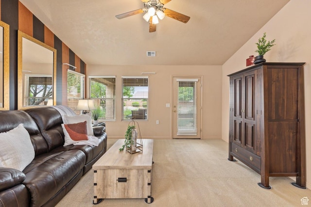 living room with a ceiling fan, light colored carpet, and baseboards