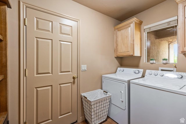 clothes washing area with cabinet space and washing machine and dryer