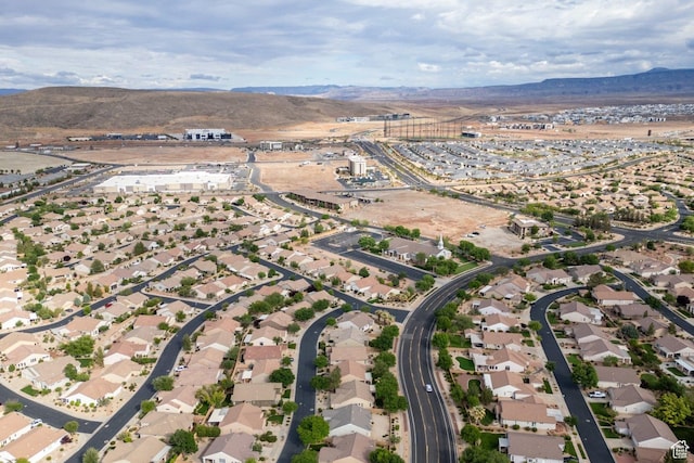 aerial view of property and surrounding area with a mountain backdrop and nearby suburban area