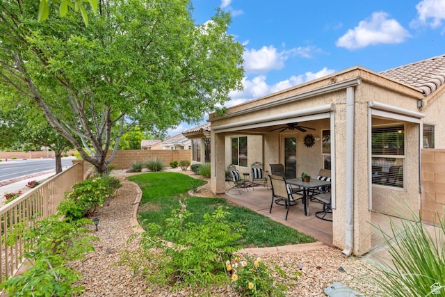 view of yard with ceiling fan and a patio