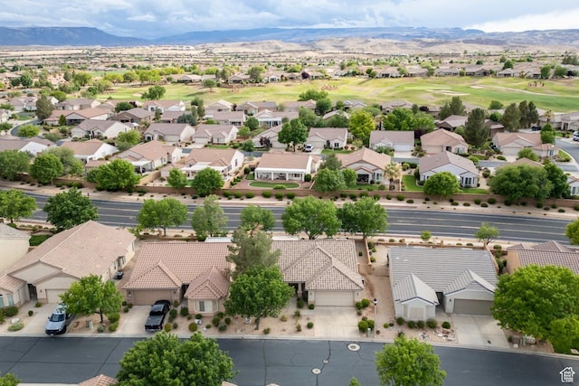 aerial view of residential area featuring a mountain backdrop and a local golf course