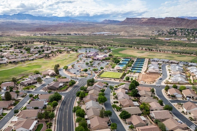 aerial view of property's location with a mountainous background, nearby suburban area, and a local golf course