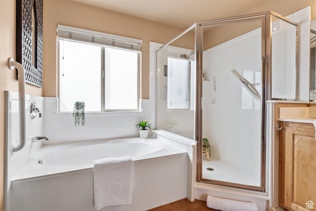 full bathroom with a stall shower and a bath