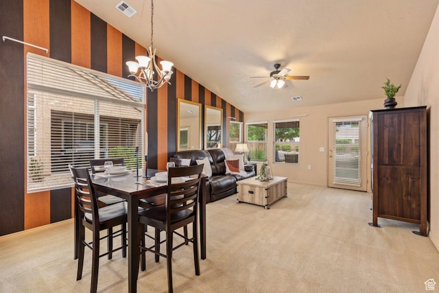 dining space with vaulted ceiling, light colored carpet, ceiling fan, a chandelier, and baseboards
