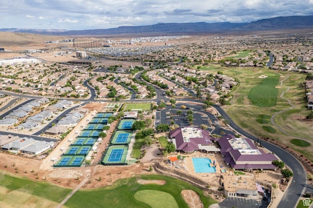 aerial overview of property's location featuring a mountain backdrop, a golf club, and nearby suburban area