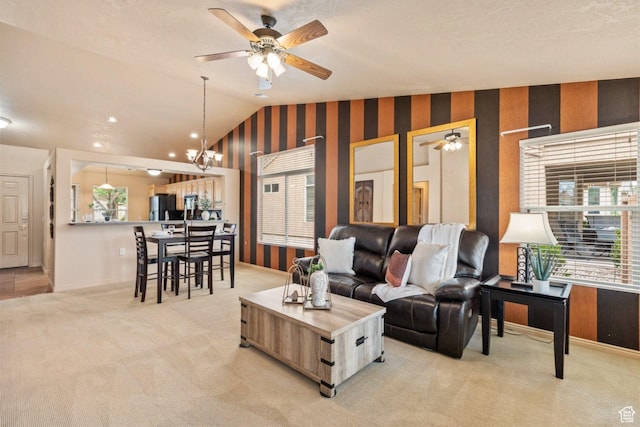 living room featuring healthy amount of natural light, vaulted ceiling, light carpet, a ceiling fan, and wallpapered walls