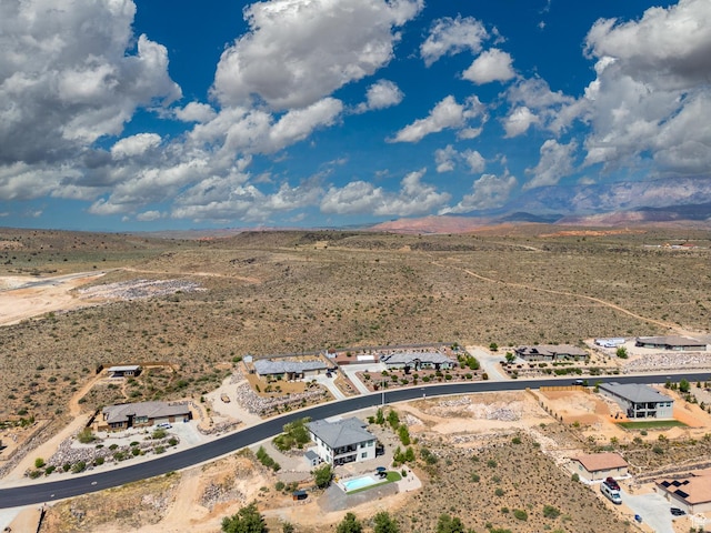 aerial view of sparsely populated area with a desert landscape and a mountainous background