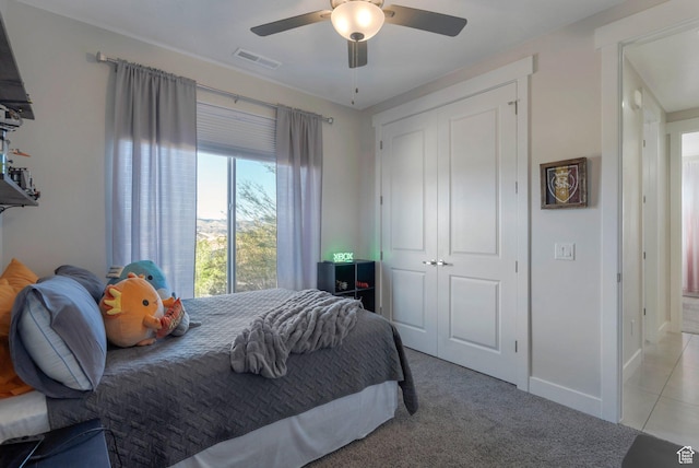 bedroom featuring a closet, light carpet, a ceiling fan, and baseboards