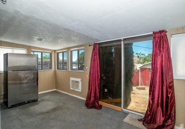 345 N Main St, Ivins, UT 84738 - empty room with a wall unit AC, carpet flooring, vaulted ceiling, baseboards, and a textured ceiling