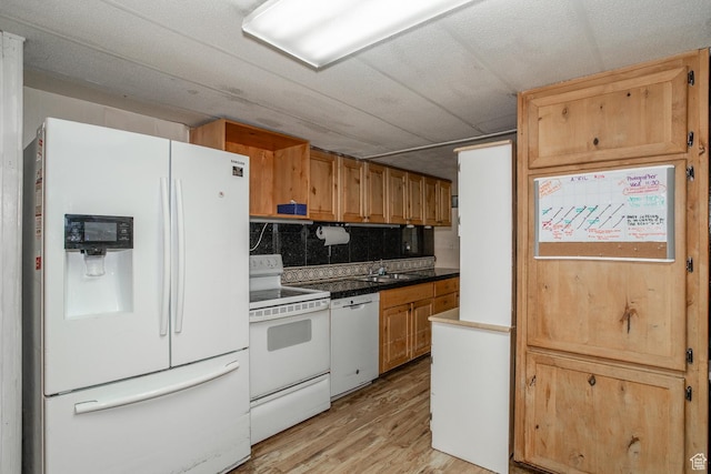 345 N Main St, Ivins, UT 84738 - kitchen with white appliances, light wood-type flooring, tasteful backsplash, a sink, and dark countertops