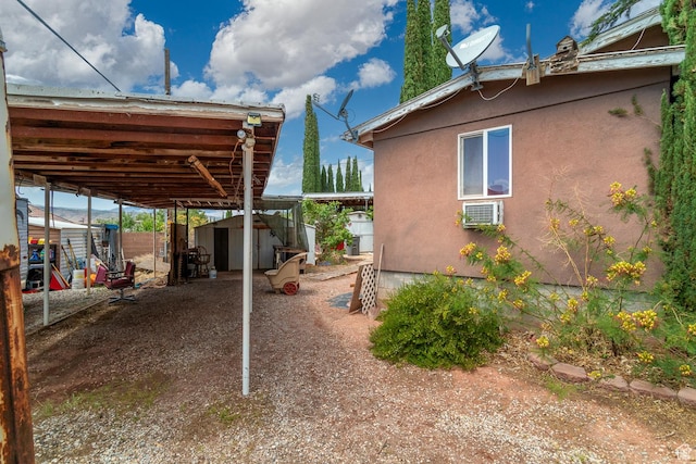345 N Main St, Ivins, UT 84738 - view of home's exterior with a storage unit, an outbuilding, stucco siding, a wall unit AC, and fence
