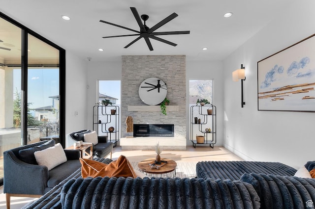living area with ceiling fan, a fireplace, recessed lighting, and baseboards