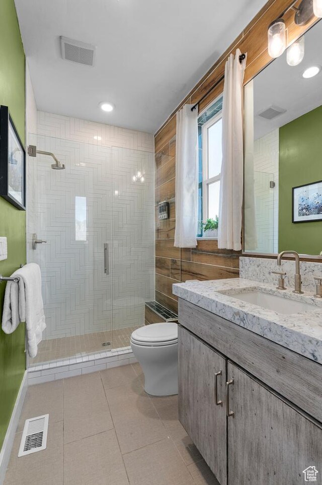 bathroom with toilet, a shower stall, vanity, and tile patterned floors