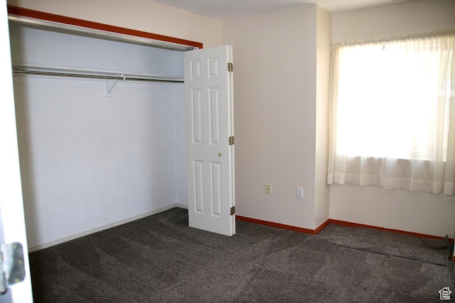 147 W 600 N Unit 111, Tooele, UT 84074 - unfurnished bedroom featuring dark colored carpet, a closet, and baseboards