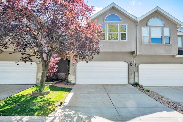 8135 S Clover Spring Ln E, Cottonwood Heights, UT 84121 - view of front of house with stucco siding, an attached garage, and driveway