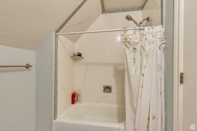 bathroom featuring a textured ceiling and shower / tub combo with curtain