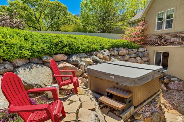 view of patio featuring a hot tub and a fenced backyard
